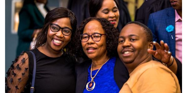 Top performer Elizabeth Labase flaked by her children at the graduation ceremony